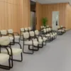 Boss beige LeatherPlus guest chair with curved arms, contoured cushions, black steel sled base, and reception seating design