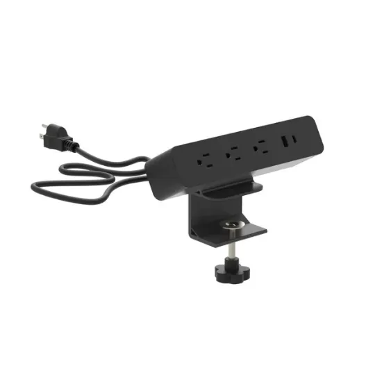 Black desktop power module with AC outlets and USB charging ports installed in a modern office desk.